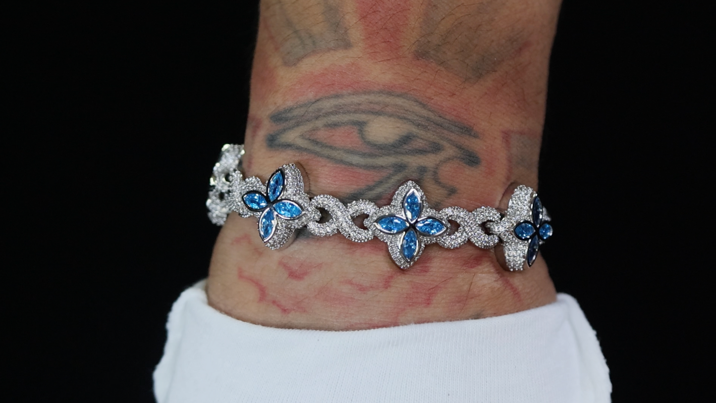 Bracelet with blue gemstones on a wrist against a black background