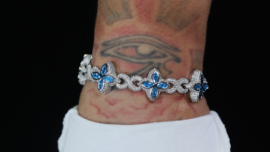 Bracelet with blue gemstones on a wrist against a black background