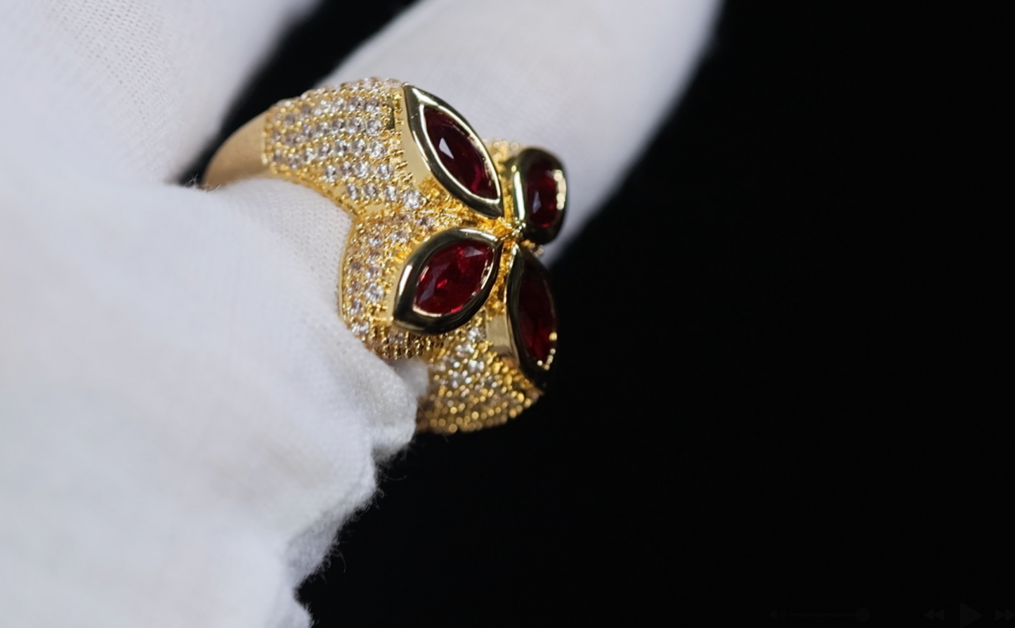 Gold ring with red gemstones on a white fabric background