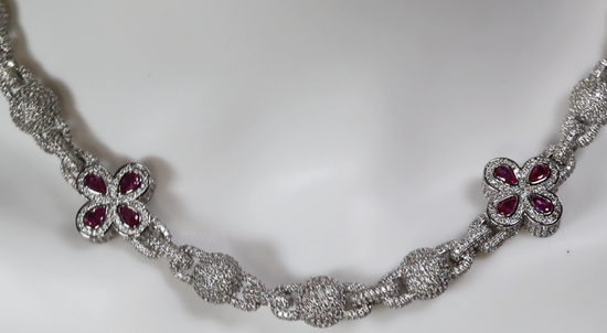 Silver necklace with floral designs and Pink gemstones on a white background