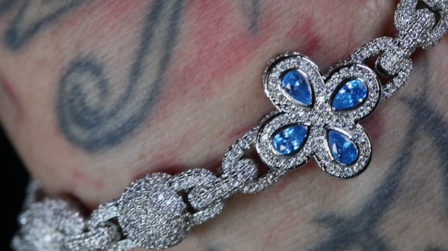 Silver bracelet with blue gemstones on a tattooed arm
